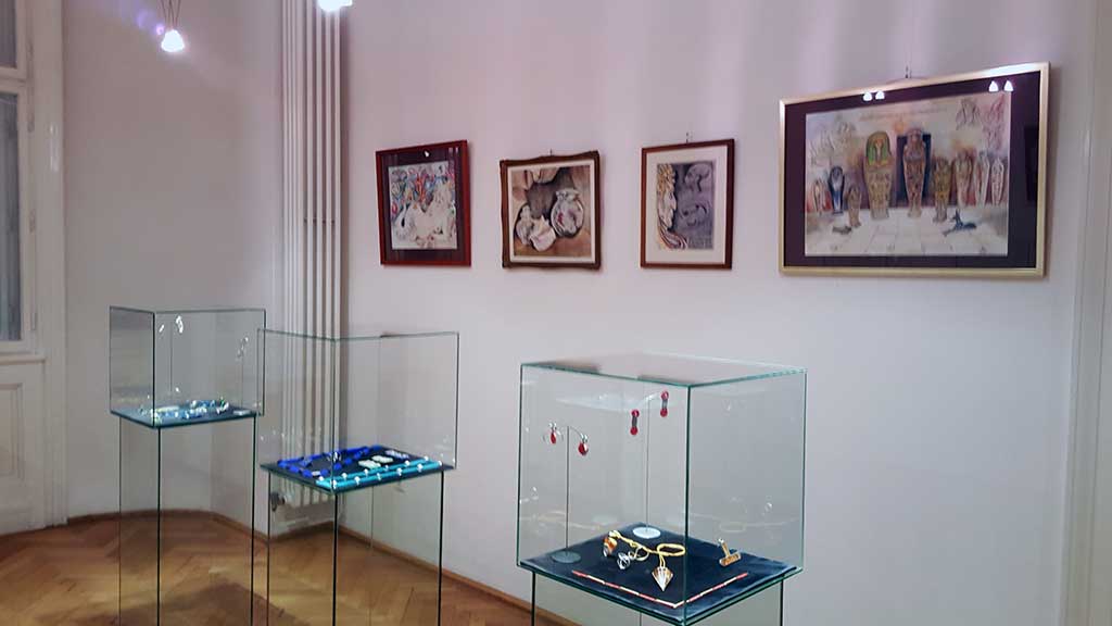 Blick auf Aquarelle und Vitrinen mit Designschmuck